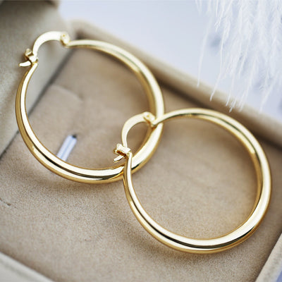 Large polished gold-tone tubular hoop earrings