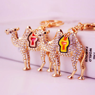 Several gold-tone rhinestone camel keychains with red and yellow saddle accents.
