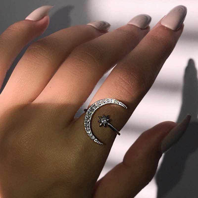 Silver crescent moon star open ring worn on finger sunlight
