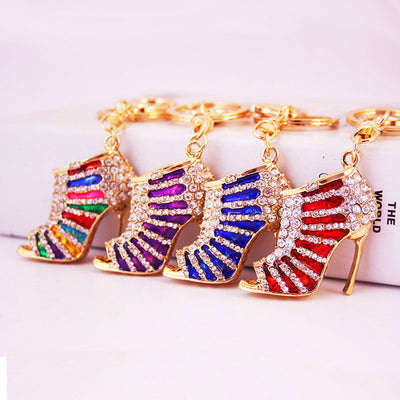 Four gold-tone high heel shoe keychains in red, blue, purple, and multicolor finishes.
