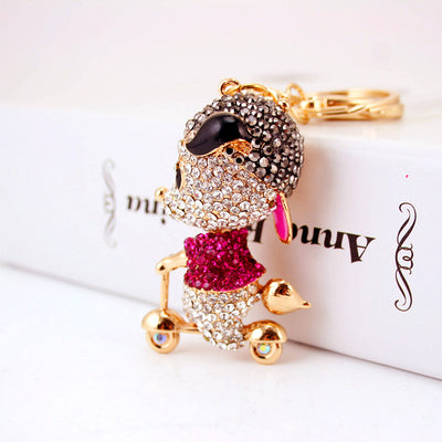 Close front view of a rhinestone mouse scooter charm attached to a gold-tone keychain.
