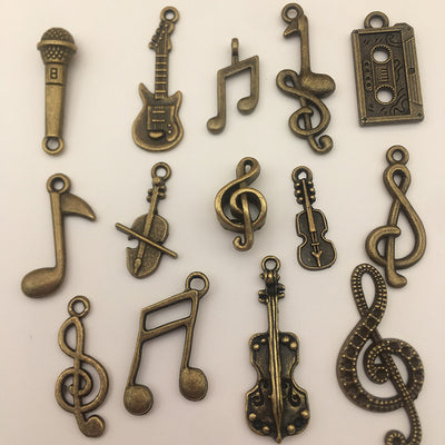 Metallic musical instrument and guitar charms arranged on a light background