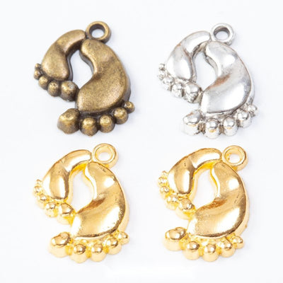 Pair of Tiny Footprint Metal Charms in Three Finishes in multiple metallic finishes displayed together on a white backgr