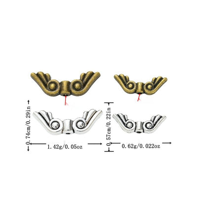 Product view of wing spacer bead showing a double-wing spacer bead with curled feather details and a central stringing h