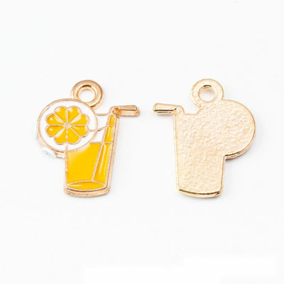 Group view of yellow drink glass with a citrus slice, straw, and gold-tone outline