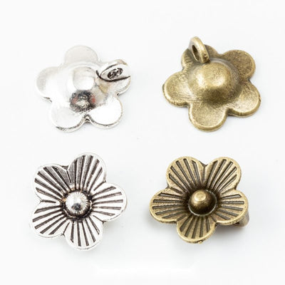 five petal flower bead caps in two antique metal finishes shown together in the available finishes
