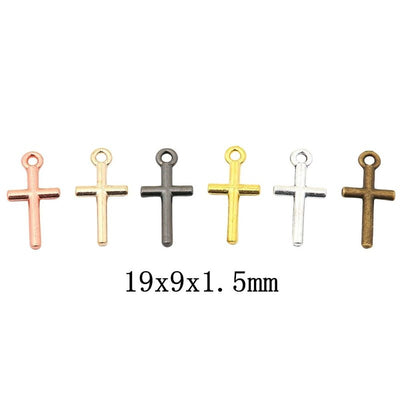 Grouped front view of simple cross charm showing smooth rounded bars and a circular top loop
