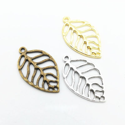Grouped front view of openwork leaf charms in the available finishes