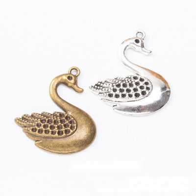 Grouped front view of swan charm showing a curved neck and dotted wing texture