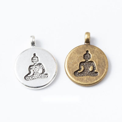 round seated yoga figure metal charms in two finishes shown together in the available finishes