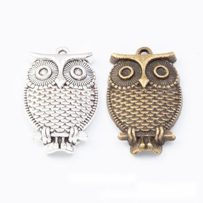 Grouped front views of the textured owl double loop connector in two antique finishes
