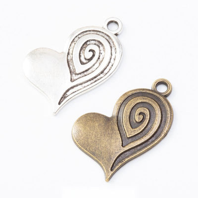 textured swirl heart metal charms in two antique finishes shown together in the available finishes