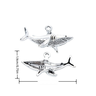 Side-profile shark charm with fins, gill lines, and textured body shown in arranged finish comparison