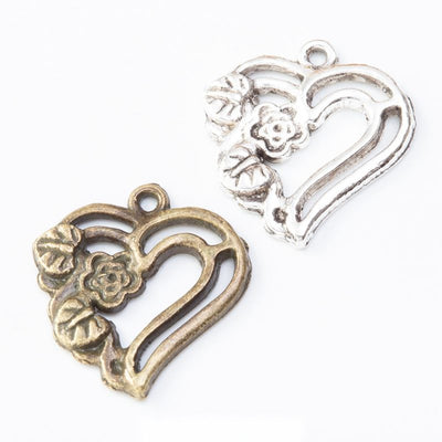 Product view of floral heart charm showing an open heart embellished with raised flowers and leaves along one side