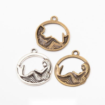 Front comparison of mermaid in a round frame metal component in 2 finishes