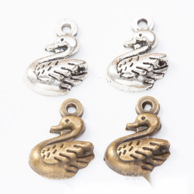Grouped front views of the small swan pendant charm in two antique metal finishes