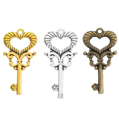 Open Heart Skeleton Key Metal Charms in Three Finishes in multiple metallic finishes displayed together on a white backg