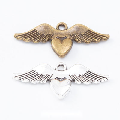 Heart charms flanked by long feather-textured wings arranged together on a white background.