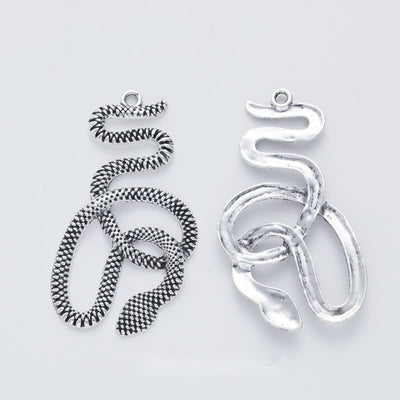 Front-facing arrangement of coiled snake charms on a white background