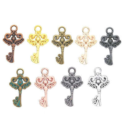 Grouped front views of the ornate heart scroll key charm in nine metal finishes