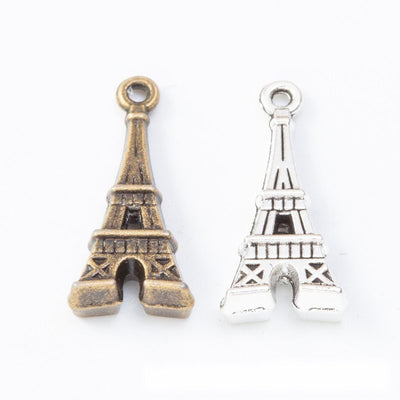 detailed eiffel tower metal charms in two antique finishes shown together in the available finishes