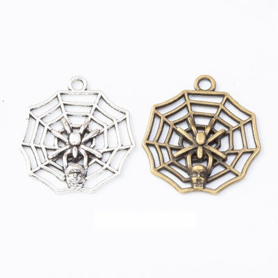 Product photo 1 of the spider web charm highlighting its round open spider web with a small spider at center