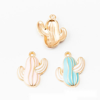 Assorted enamel cactus charms arranged together on a white background