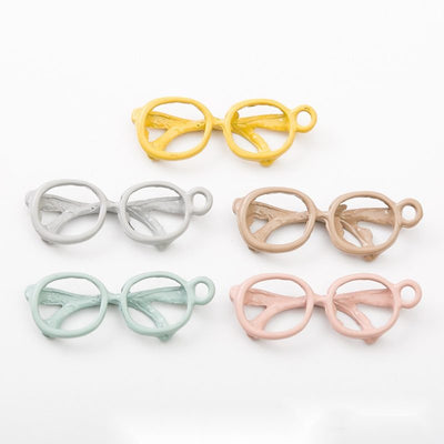 Assorted eyeglasses charms arranged together on a white background