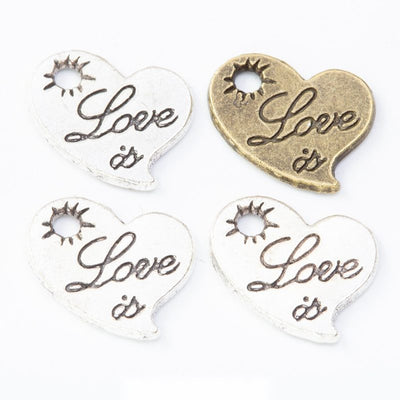 Grouped front views of the engraved love heart metal charm in two antique finishes