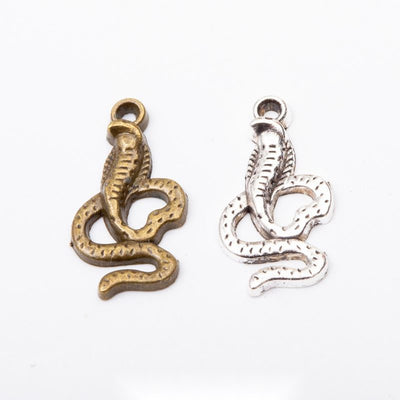Grouped front views of the coiled cobra snake metal charm in two antique finishes