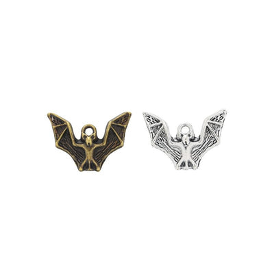 Grouped front views of the spread wing bat metal charm in two antique finishes