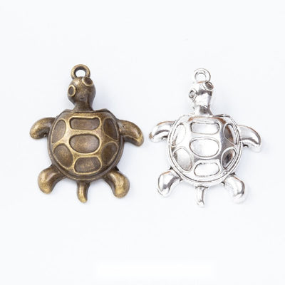 Turtle charms with open rounded shell recesses and curved flippers arranged together on a white background.