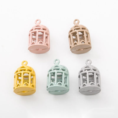 Overview of birdcage charm pieces on a white background
