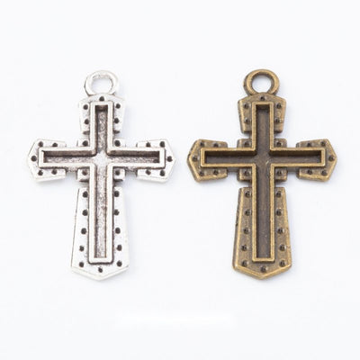 Layered Cross metal pieces shown in the available finishes.