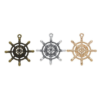 Assorted ship wheel charm pendants displayed together on a white background