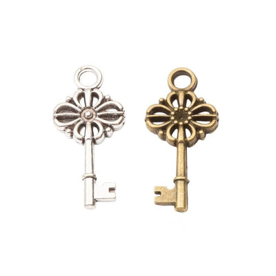 Group view of a slim vintage-style key has an open floral bow and small top loop