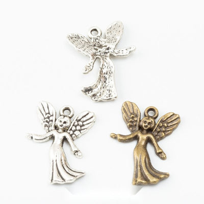 Assorted winged angel charms arranged together on a white background