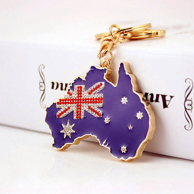 Blue Australia map keychain with a rhinestone flag resting against a white box