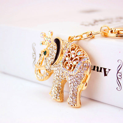 Side view of a crowned gold-tone elephant covered in clear and iridescent stones.