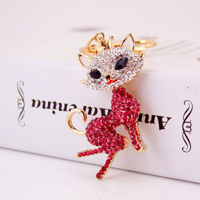 Pink rhinestone crowned cat pendant attached to a gold-tone key ring.