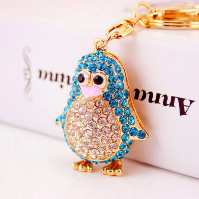 Close-up of a blue rhinestone penguin with a clear stone belly and gold-tone feet.