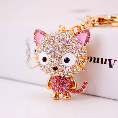 Close-up of a pink rhinestone cat charm attached to gold-tone keychain hardware.