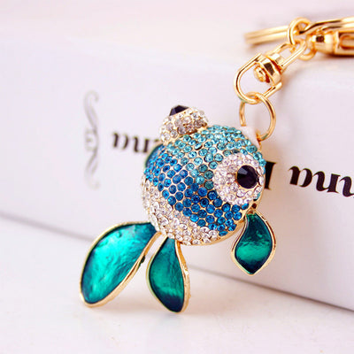 Close-up of a blue rhinestone fish with turquoise fins and clear stone accents.