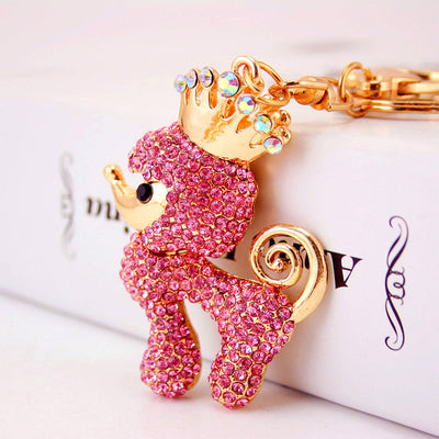 Close-up of a pink rhinestone poodle wearing a jeweled gold-tone crown.