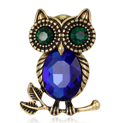 Front product view of the owl brooch pin in gold and blue