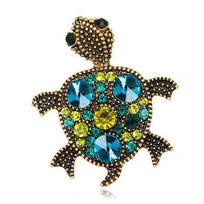 Front product view of the turtle brooch pin in gold and aqua