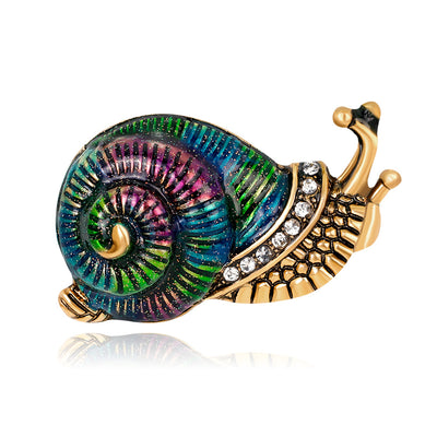 Front product view of the snail brooch pin in gold and green