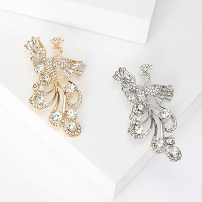 Silver Phoenix, Gold Phoenix brooch styles arranged on a light display