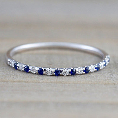 Product view showing silver-tone slim half-eternity ring with colored stones
