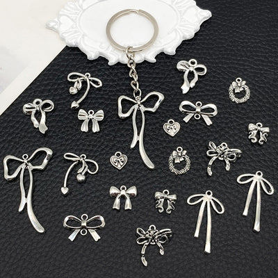 Black bow and butterfly charms arranged on a light background